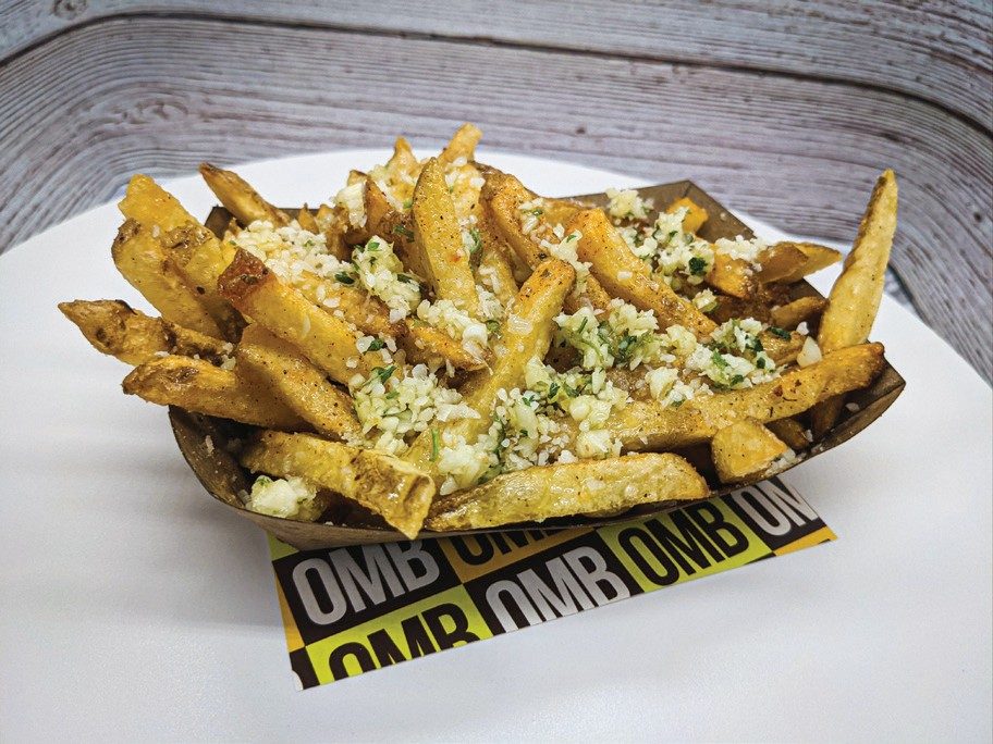 Basket of Oh My Burger garlic parmesan fries on branded OMB paper