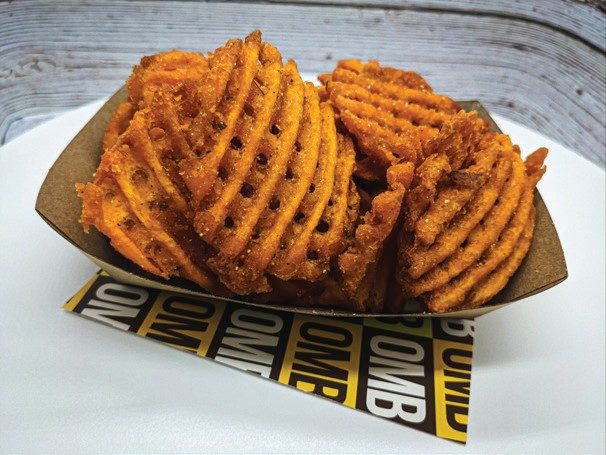 Seasoned waffle fries in an Oh My Burger basket