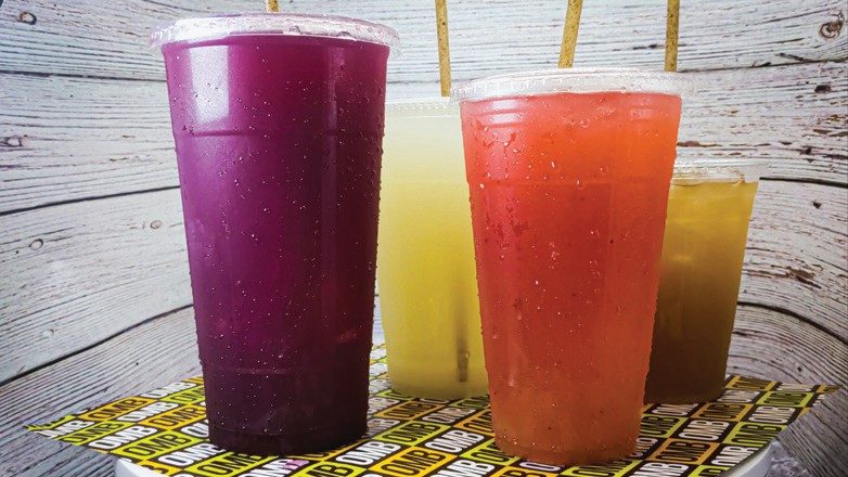Four Oh My Burger drinks in clear cups on branded OMB paper